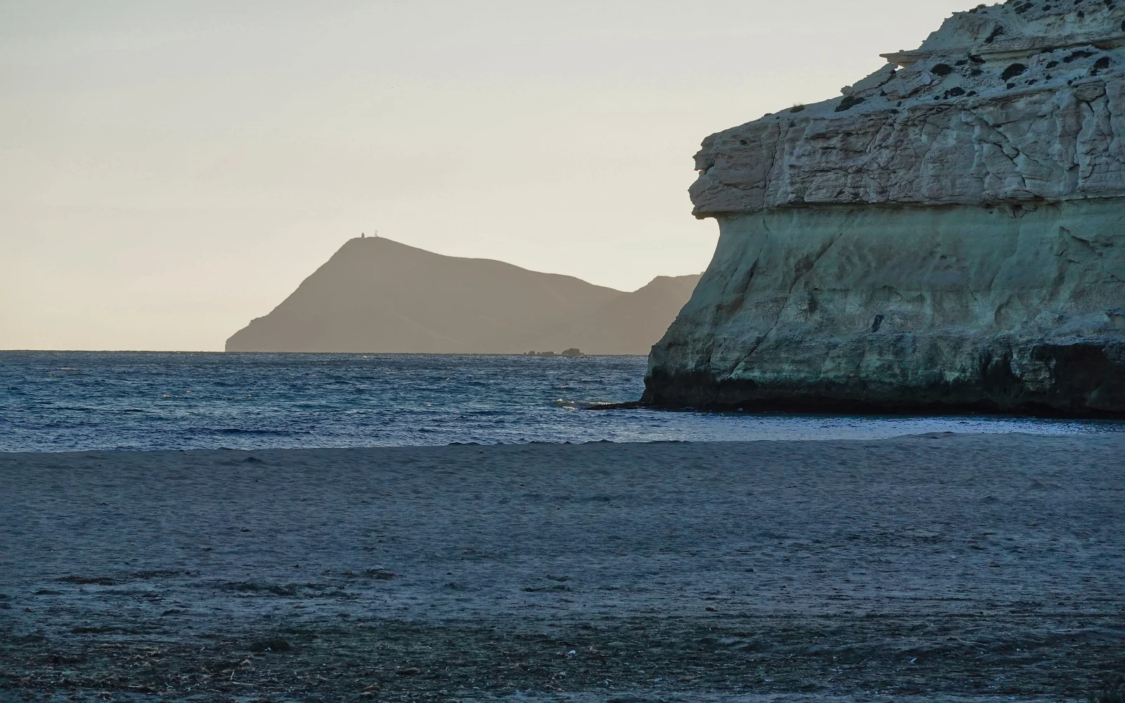 Atardecer en la playa de Agua Amarga con la costa al fondo